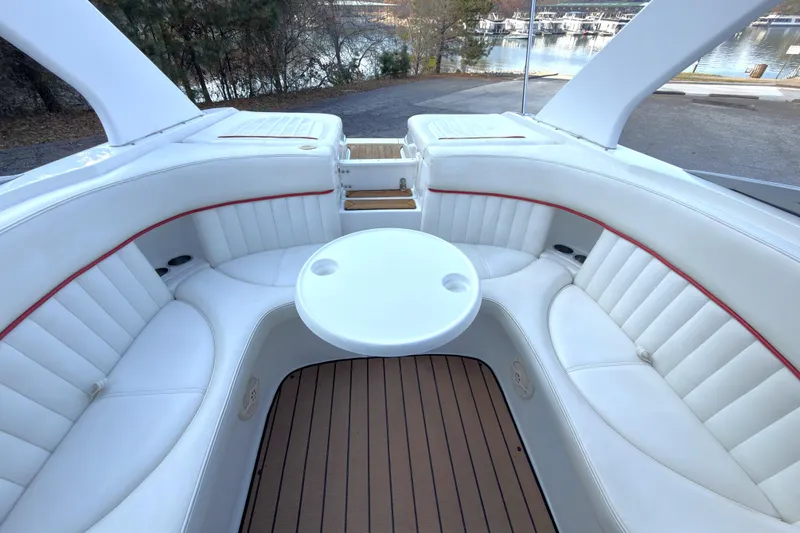 Slide: The Image of 2004 Cobalt 262 boat interior with white seating and round table, dockside view. - 18