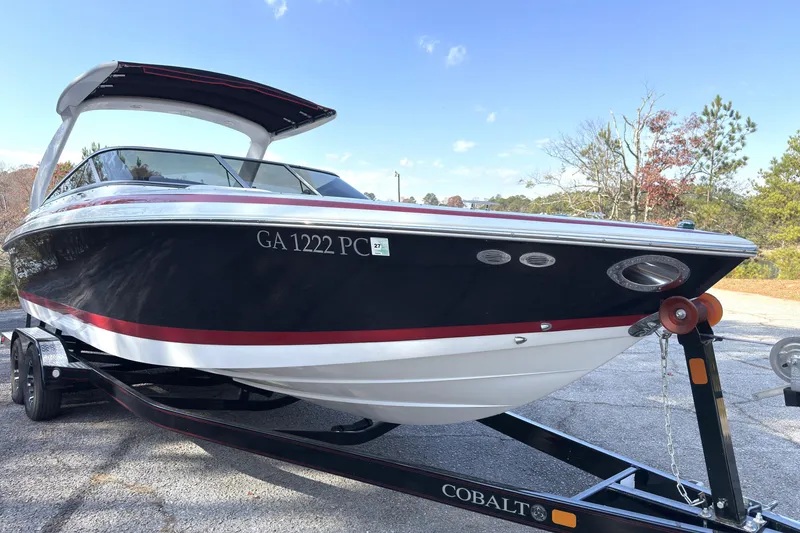 Slide: The Image of 2004 Cobalt 262 boat on trailer, black and red design, parked outdoors. - 22