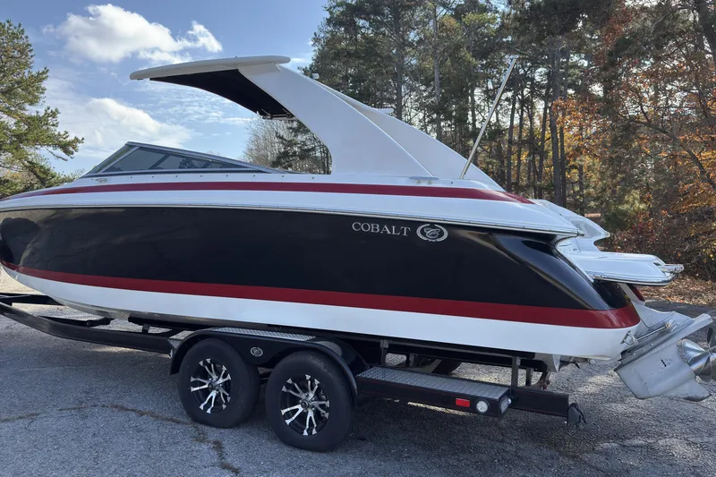 Slide: The Image of 2004 Cobalt 262 boat on trailer, black and red design, parked outdoors. - 3