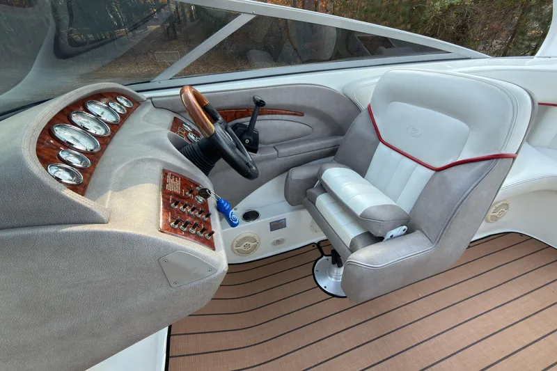 Slide: The Image of 2004 Cobalt 262 boat interior with steering wheel, gauges, and cushioned captain's chair. - 8