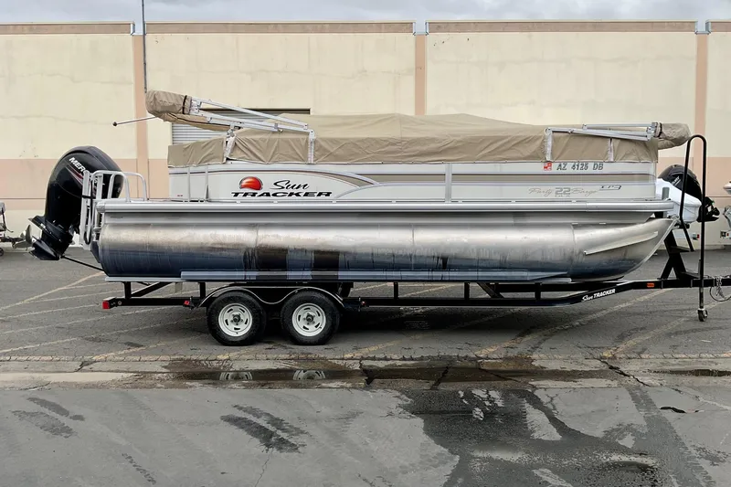The Image of 2015 Sun Tracker Party Barge 22 XP3 pontoon boat on trailer, parked outdoors. - 0