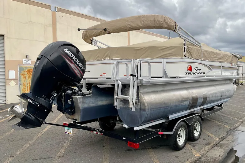 Slide: The Image of 2015 Sun Tracker Party Barge 22 XP3 pontoon boat with outboard motor, parked outdoors. - 3