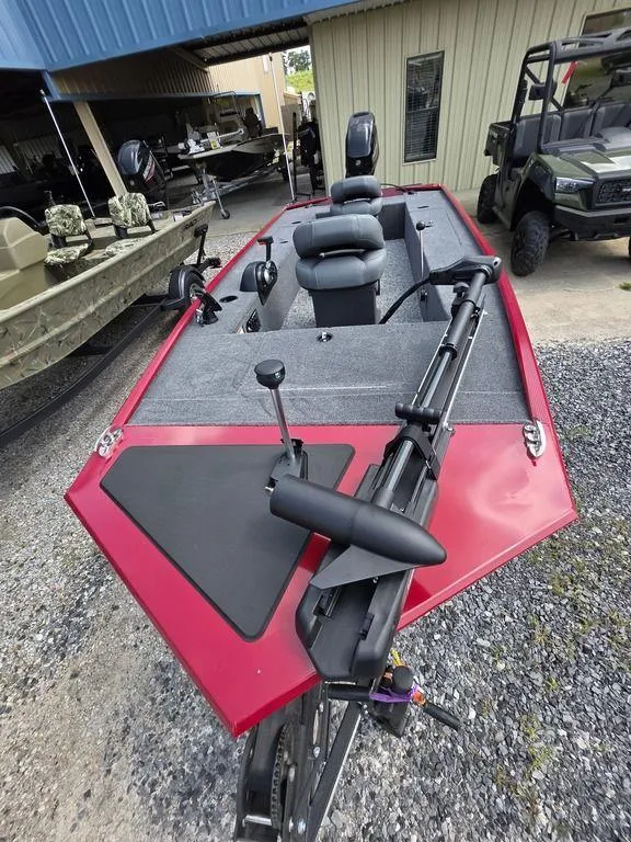 Slide: The Image of 2025 Tracker Panfish™ 17 boat with red exterior, equipped for fishing, parked on gravel. - 7