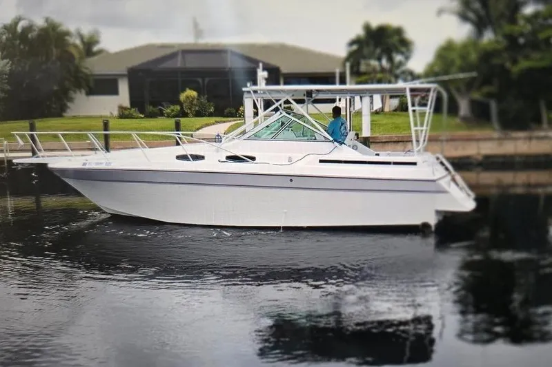 Slide: The Image of 1987 Chris-Craft 284 Amerosport boat on calm water near a residential area. - 0