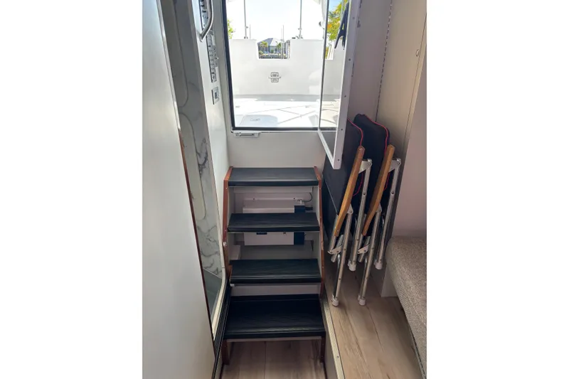 Slide: The Image of Stairway inside 1987 Chris Craft Amerosport boat, leading to deck with folding chairs. - 17