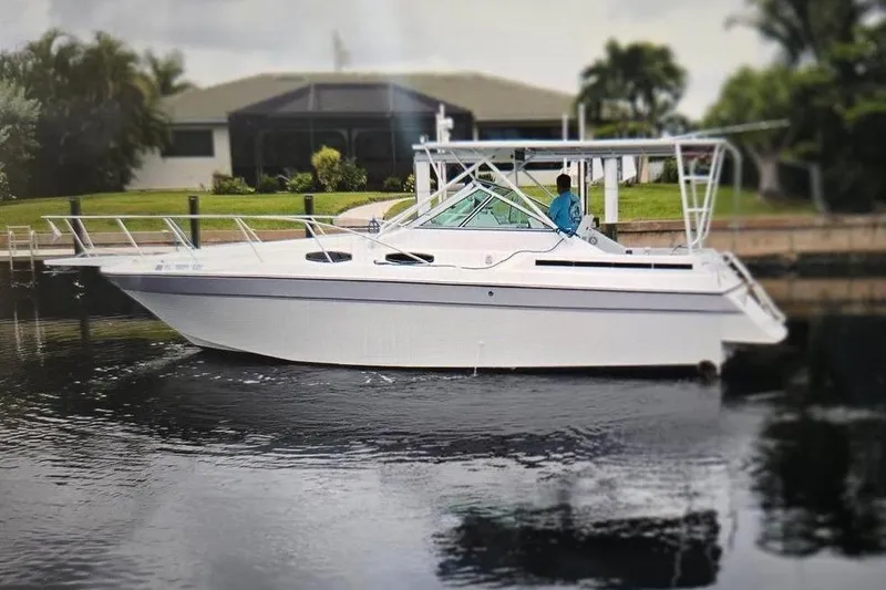 Slide: The Image of 1987 Chris Craft Amerosport boat docked on calm water, surrounded by greenery. - 3