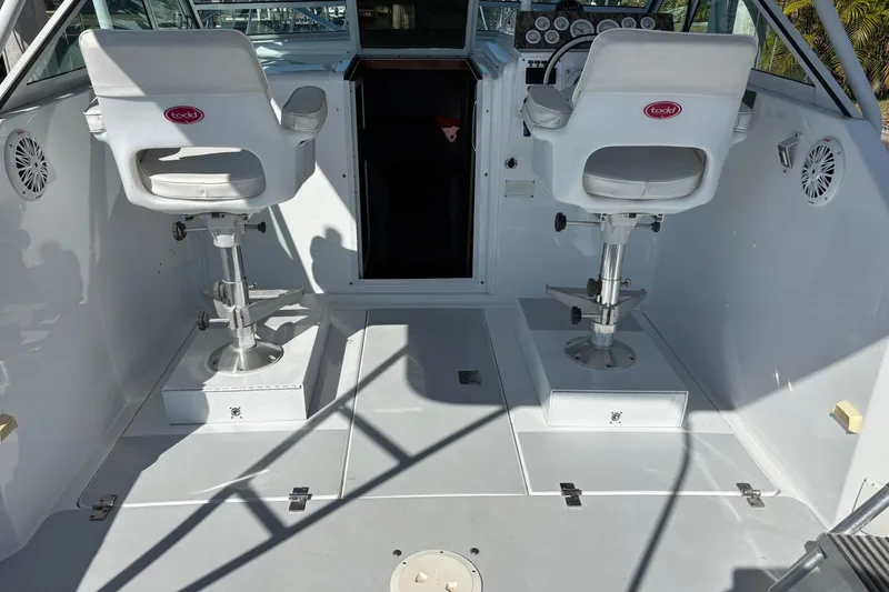 Slide: The Image of 1987 Chris Craft Amerosport boat cockpit with dual white captain chairs and control panel. - 6