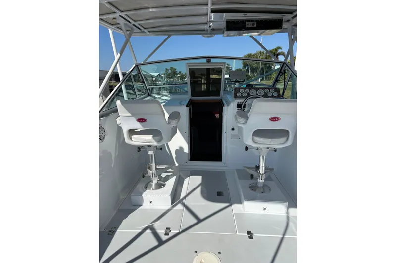 Slide: The Image of 1987 Chris Craft Amerosport boat interior with helm and two white captain chairs. - 7