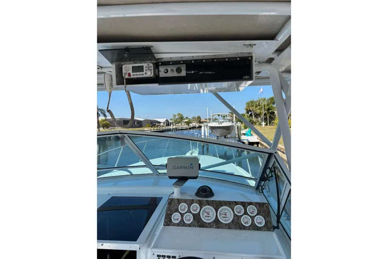 Slide: The Image of 1987 Chris Craft Amerosport boat dashboard with Garmin navigation, docked in a scenic canal. - 9