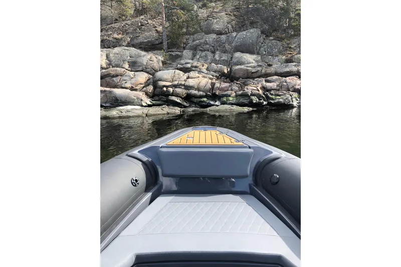 Slide: The Image of Bow view of 2026 Northstar Orion 6 boat near rocky shoreline. - 2