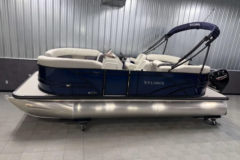 The Image of 2026 Sylvan Mirage 820 LZ pontoon boat with blue exterior and white seating in showroom. - 0