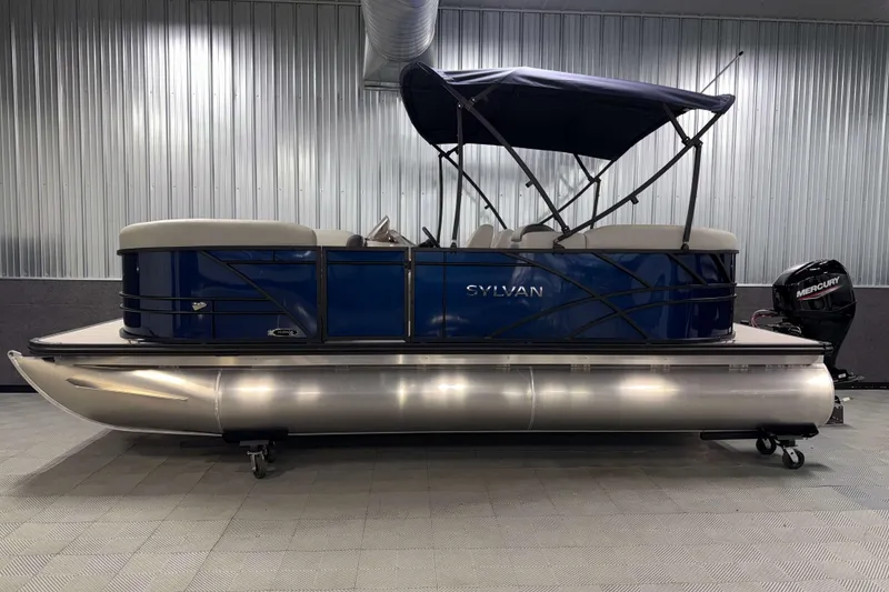 Slide: The Image of 2026 Sylvan Mirage 820 LZ pontoon boat with blue exterior and Mercury outboard motor. - 19