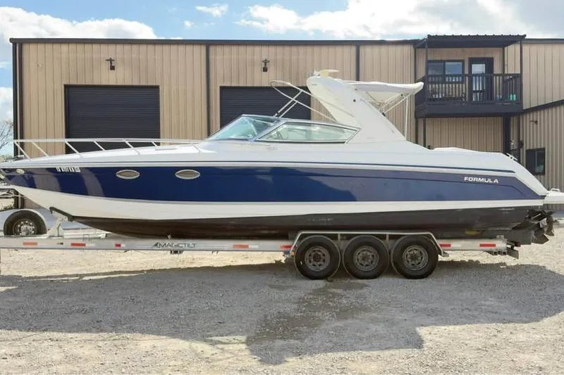The Image of 2005 Formula 330 Sun Sport boat on trailer, parked outside a warehouse. - 1
