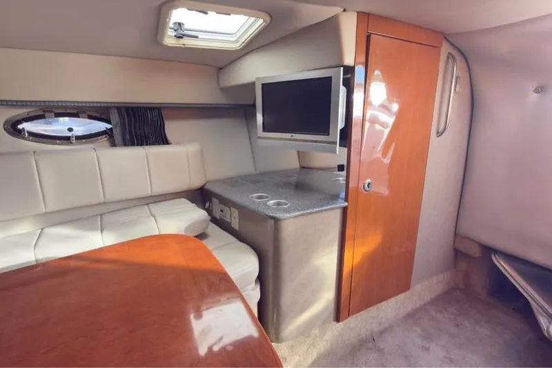 Slide: The Image of Interior of 2005 Formula 330 Sun Sport boat with seating, TV, and wooden cabinetry. - 11
