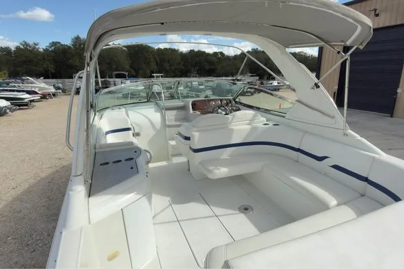 Slide: The Image of 2005 Formula 330 Sun Sport boat with spacious seating and canopy in a marina setting. - 8