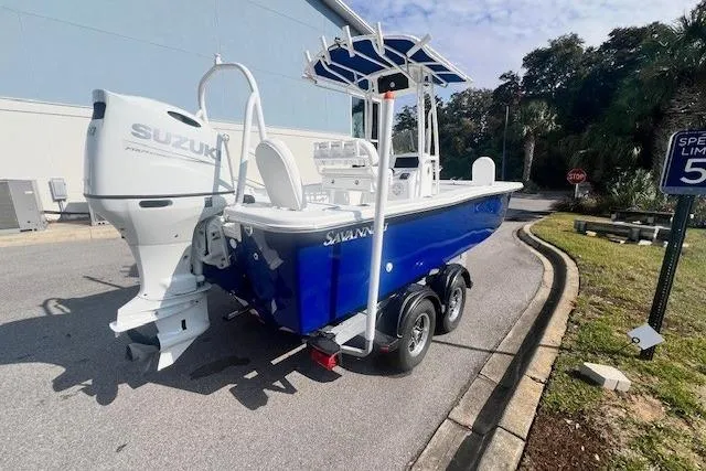 Slide: The Image of 2024 Savannah SS21 boat with Suzuki engine on a trailer, parked near a speed limit sign. - 3