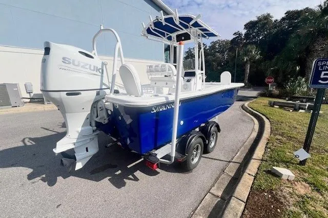 Slide: The Image of 2024 Savannah SS21 boat with Suzuki engine on trailer, parked outdoors. - 4