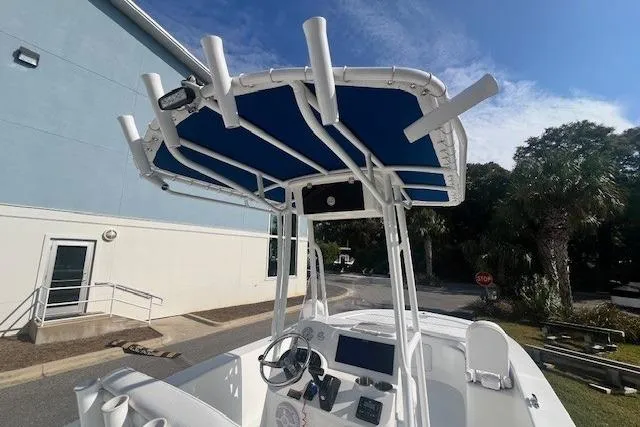 Slide: The Image of 2024 Savannah SS21 boat with blue canopy, docked near a building and palm trees. - 5