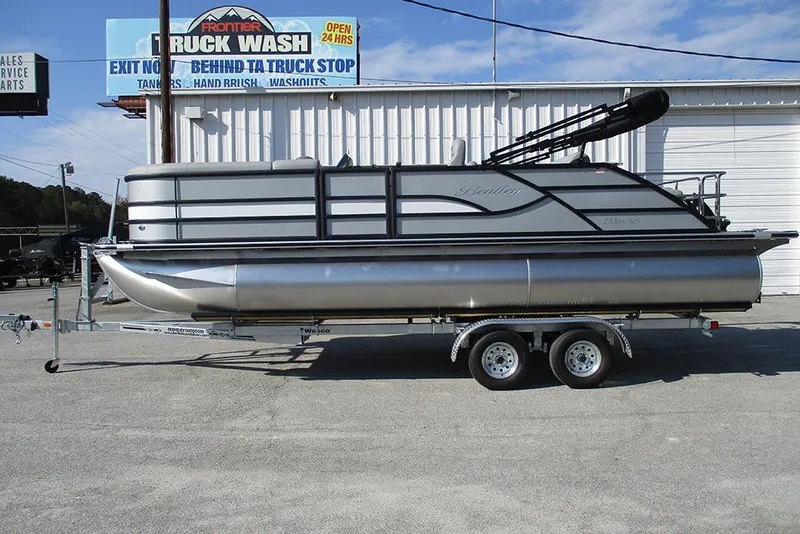 The Image of 2026 Bentley Pontoons Legacy 220 Swingback on trailer, parked near truck wash facility. - 1