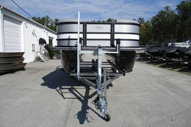 Slide: The Image of 2026 Bentley Pontoons Legacy 220 Swingback on trailer, parked outdoors near a white building. - 4