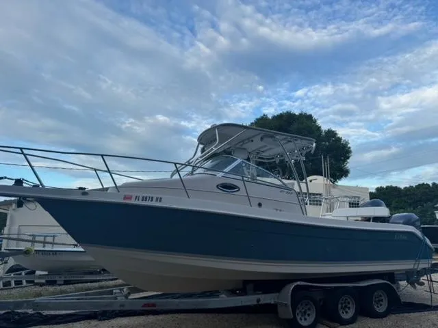 The Image of 2007 Cobia 270 boat on trailer under cloudy sky. - 0
