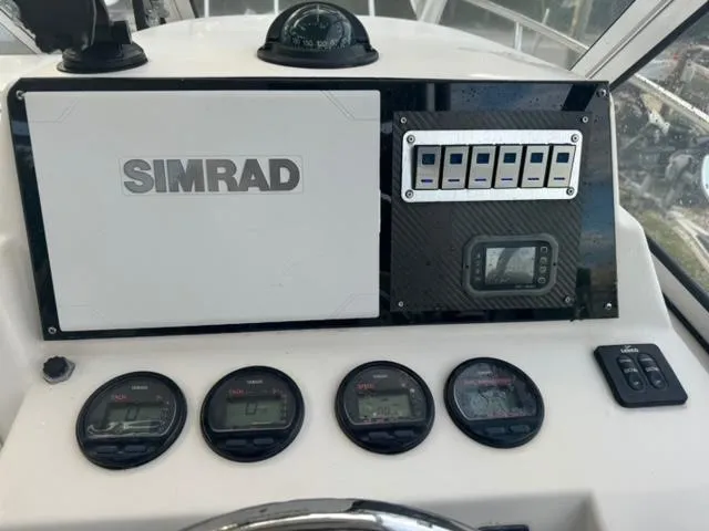 Slide: The Image of Dashboard of a 2007 Cobia 270 boat with Simrad navigation system and gauges. - 11