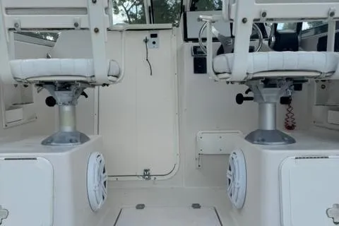 Slide: The Image of 2007 Cobia 270 boat interior with dual white captain chairs and marine speakers. - 14