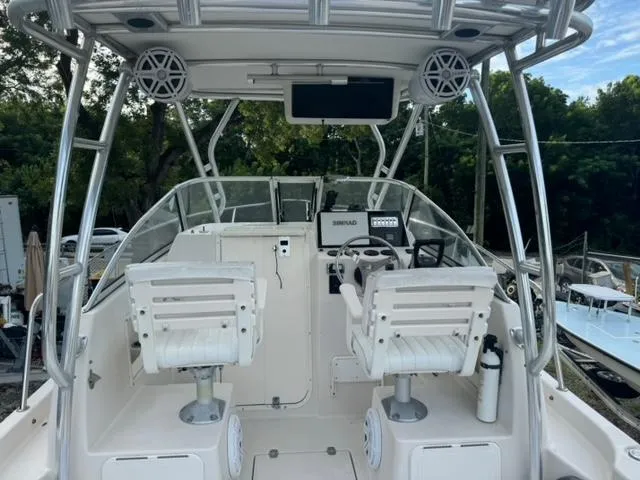 Slide: The Image of 2007 Cobia 270 boat cockpit with dual white captain chairs and navigation equipment. - 5