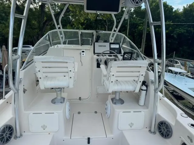 Slide: The Image of 2007 Cobia 270 boat interior with dual white captain chairs and control panel. - 6