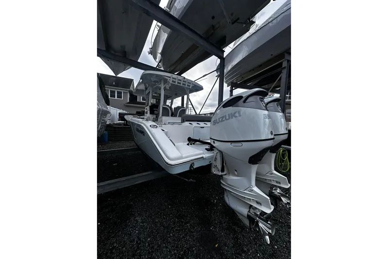 Slide: The Image of 2023 Sea Pro 320 DLX Offshore boat with dual Suzuki outboard engines in storage. - 17