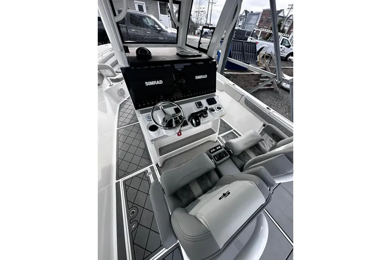 Slide: The Image of 2023 Sea Pro 320 DLX Offshore boat cockpit with Simrad electronics and luxurious seating. - 2