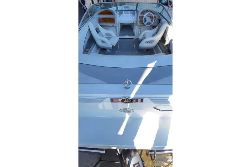 Slide: The Image of 1998 Cobalt 220 boat interior with white seating and steering wheel. - 12
