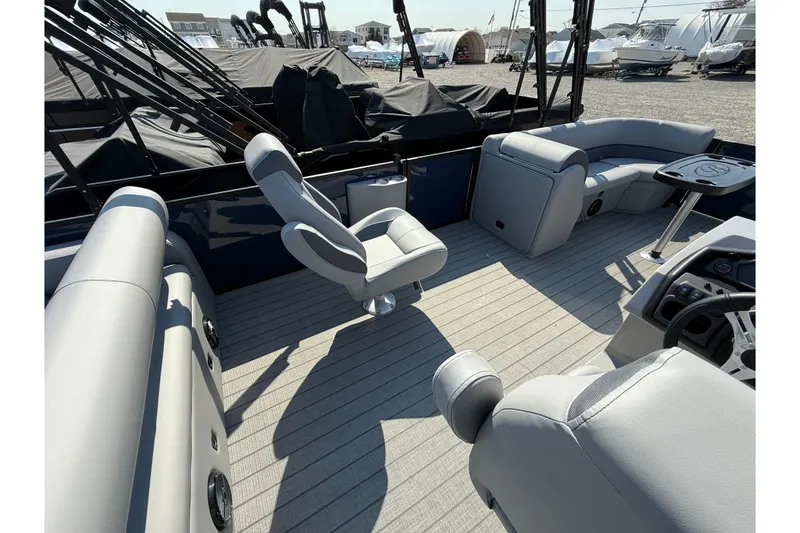 Slide: The Image of 2026 Bentley Pontoons Legacy 243 Swingback, sleek design, docked on gravel surface. - 3