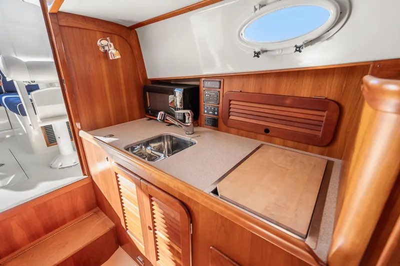 Slide: The Image of 2007 Hinckley Picnic Boat 36 EP interior with wooden cabinetry and compact kitchen area. - 16