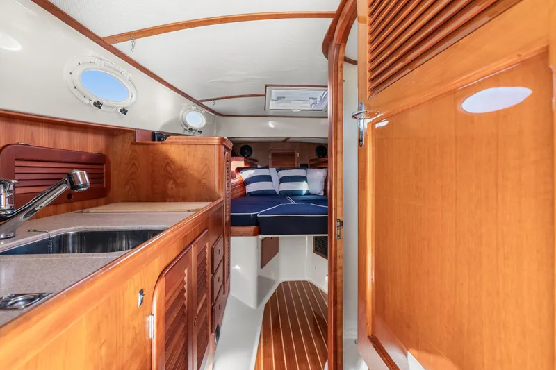 Slide: The Image of Interior of 2007 Hinckley Picnic Boat 36 EP with wooden cabinetry and cozy sleeping area. - 17