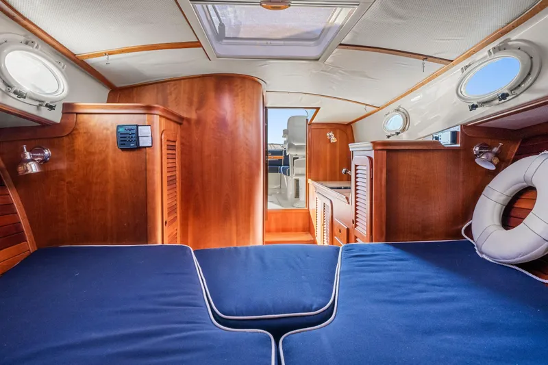 Slide: The Image of Interior of 2007 Hinckley Picnic Boat 36 EP with wooden finish and blue cushions. - 19