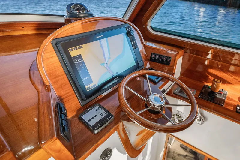Slide: The Image of Helm of 2007 Hinckley Picnic Boat 36 EP with navigation display and wooden steering wheel. - 14