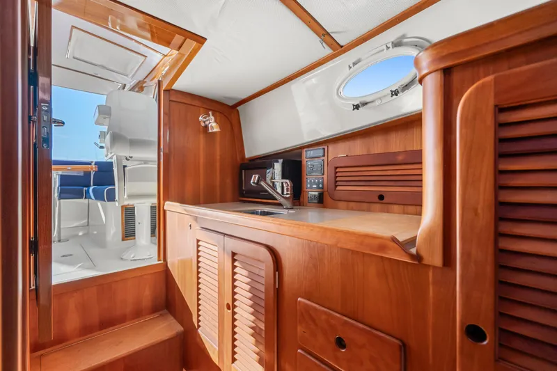 Slide: The Image of 2007 Hinckley Picnic Boat 36 EP interior with wooden cabinetry and compact kitchen area. - 15