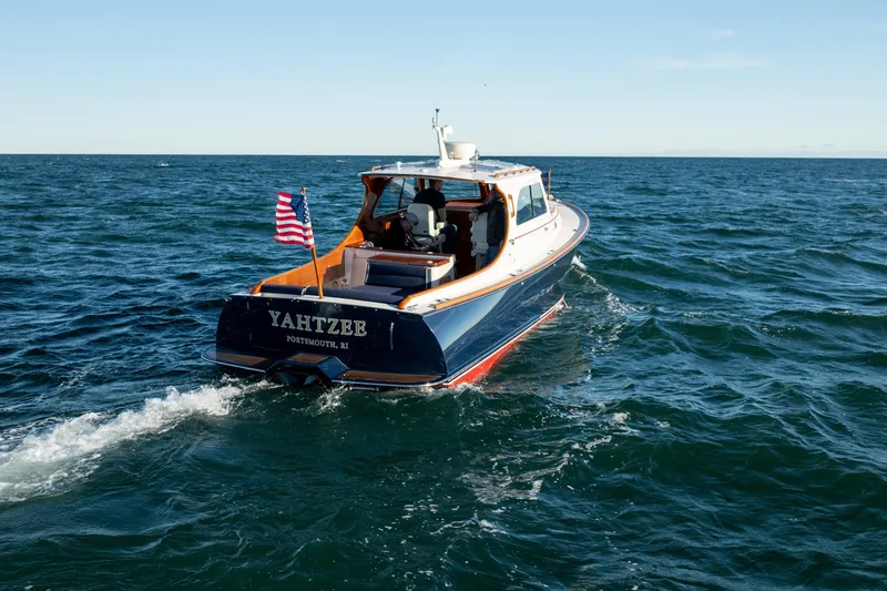 Slide: The Image of 2007 Hinckley Picnic Boat 36 EP cruising on open water with American flag. - 3