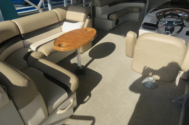 Slide: The Image of 2013 Cypress Cay Seabreeze 230 interior with beige seating and wooden table. - 5