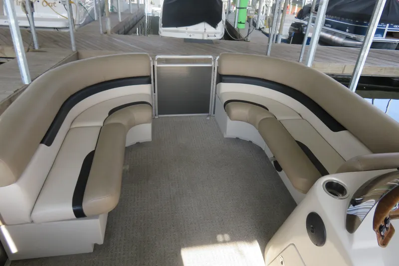 Slide: The Image of 2013 Cypress Cay Seabreeze 230 pontoon boat interior with beige seating and carpeted floor. - 7