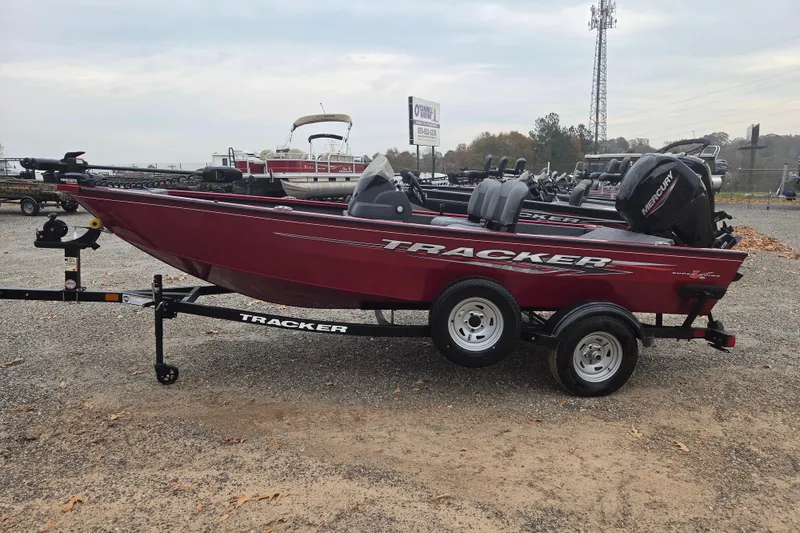 The Image of 2025 Tracker Super Guide V-16 SC boat on trailer, red exterior, parked outdoors. - 0