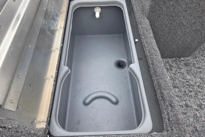 Slide: The Image of 2025 Tracker Super Guide V-16 SC livewell with gray interior and drainage system. - 11