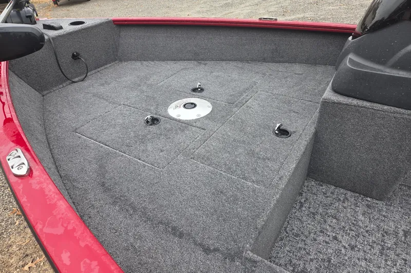 Slide: The Image of 2025 Tracker Super Guide V-16 SC boat interior with gray carpeted deck. - 12