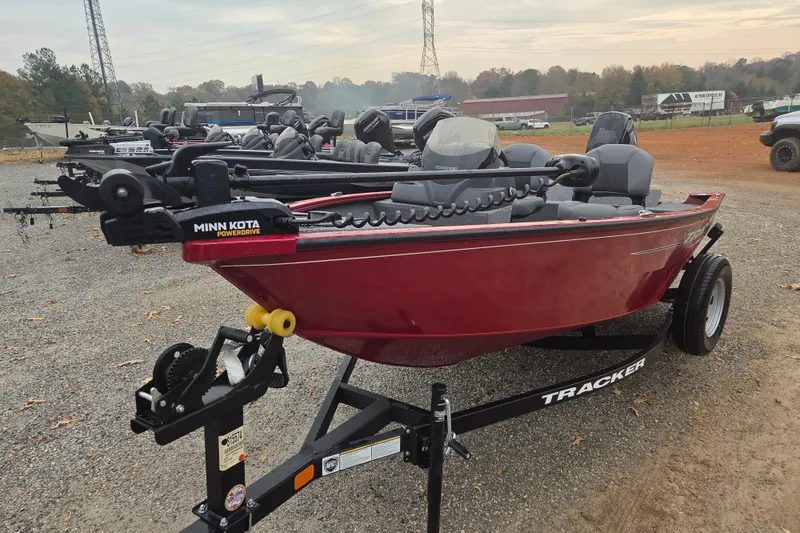 Slide: The Image of 2025 Tracker Super Guide V-16 SC boat with Minn Kota PowerDrive, parked on gravel. - 2