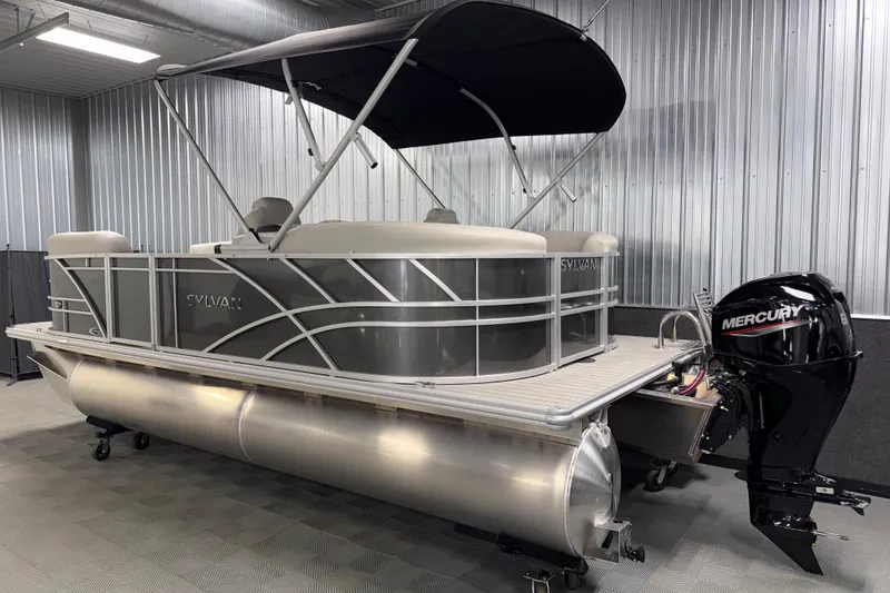 Slide: The Image of 2026 Sylvan Mirage 8520 LZ pontoon boat with Mercury outboard motor in a showroom. - 22