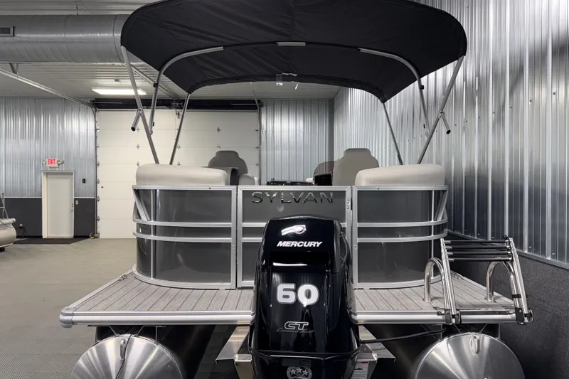 Slide: The Image of 2026 Sylvan Mirage 8520 LZ pontoon boat with Mercury 60 CT engine in a metal garage. - 23