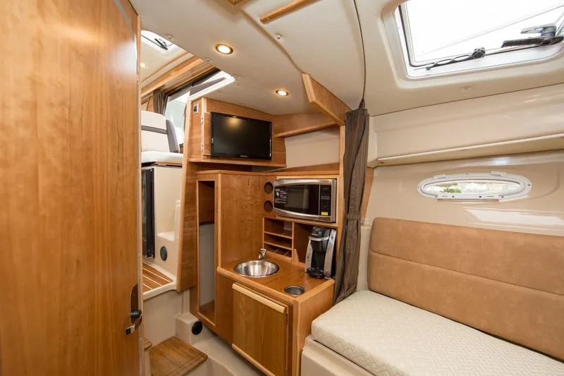 Slide: The Image of Manufacturer Provided Image: Interior of a 2016 Cutwater 28 boat with kitchenette, TV, and seating area. - 12
