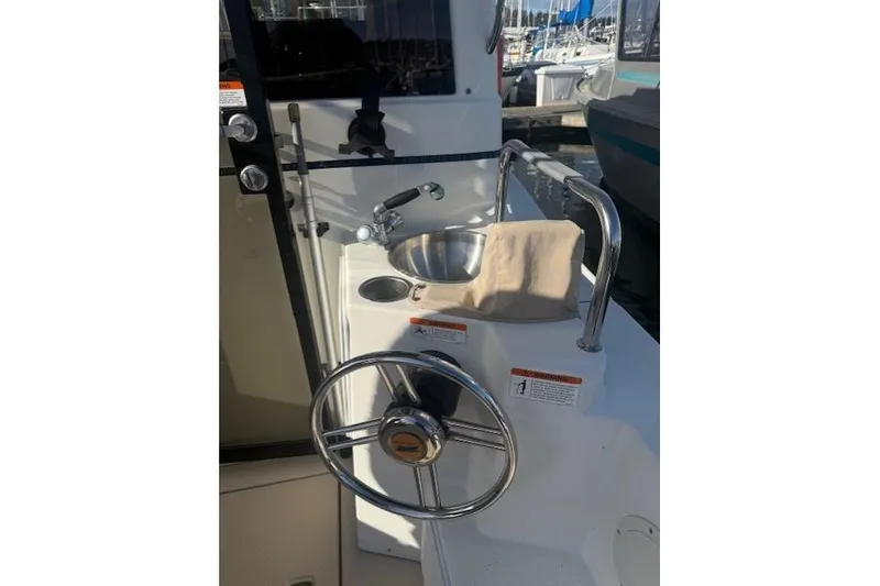 Slide: The Image of 2016 Cutwater 28 boat helm with steering wheel and sink, docked at marina. - 3