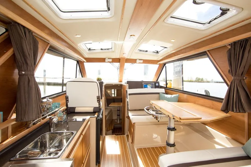 Slide: The Image of Manufacturer Provided Image: Interior of a 2016 Cutwater 28 boat with modern kitchen and dining area. - 9